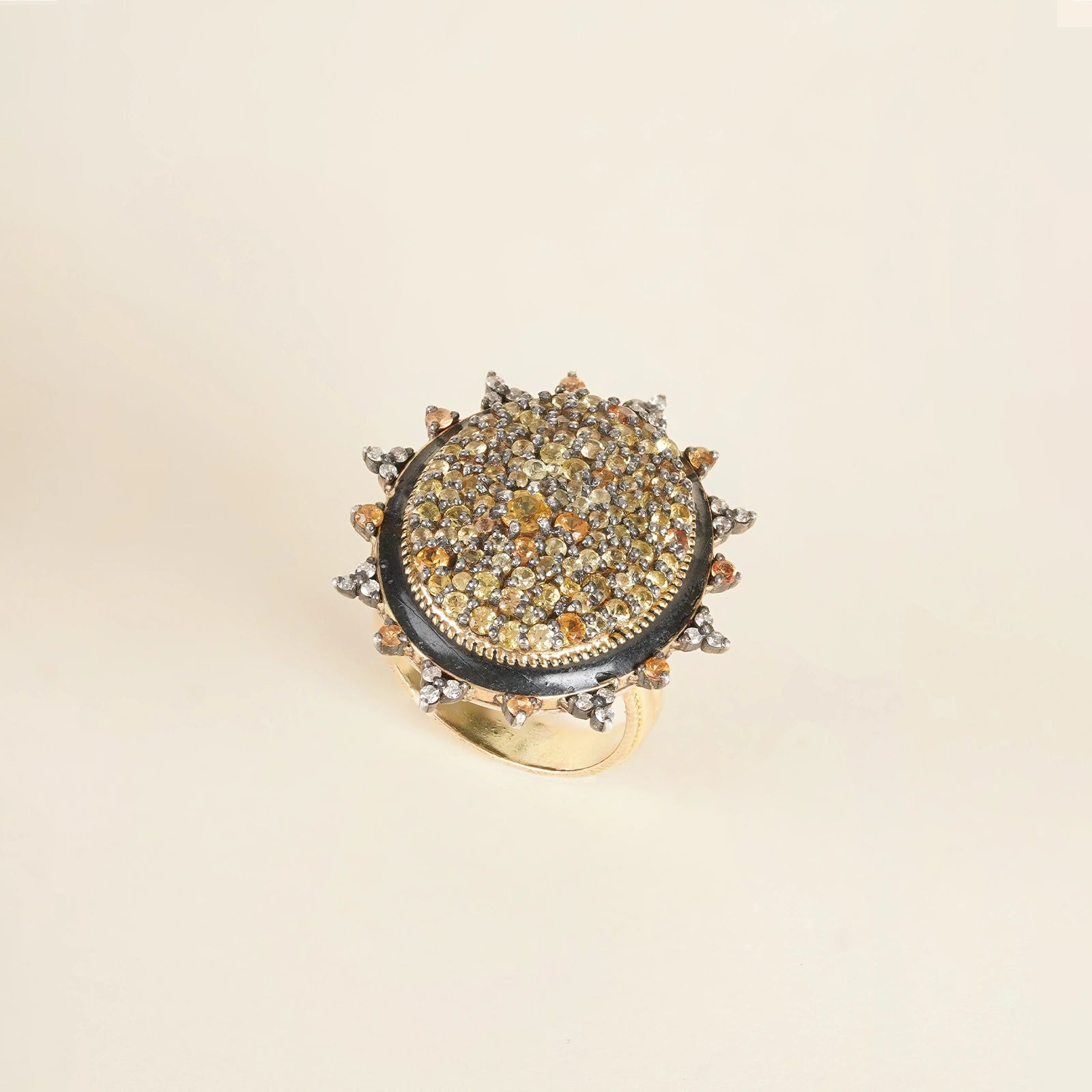 Elegant cocktail ring featuring sunlit sapphires and an enamel band.