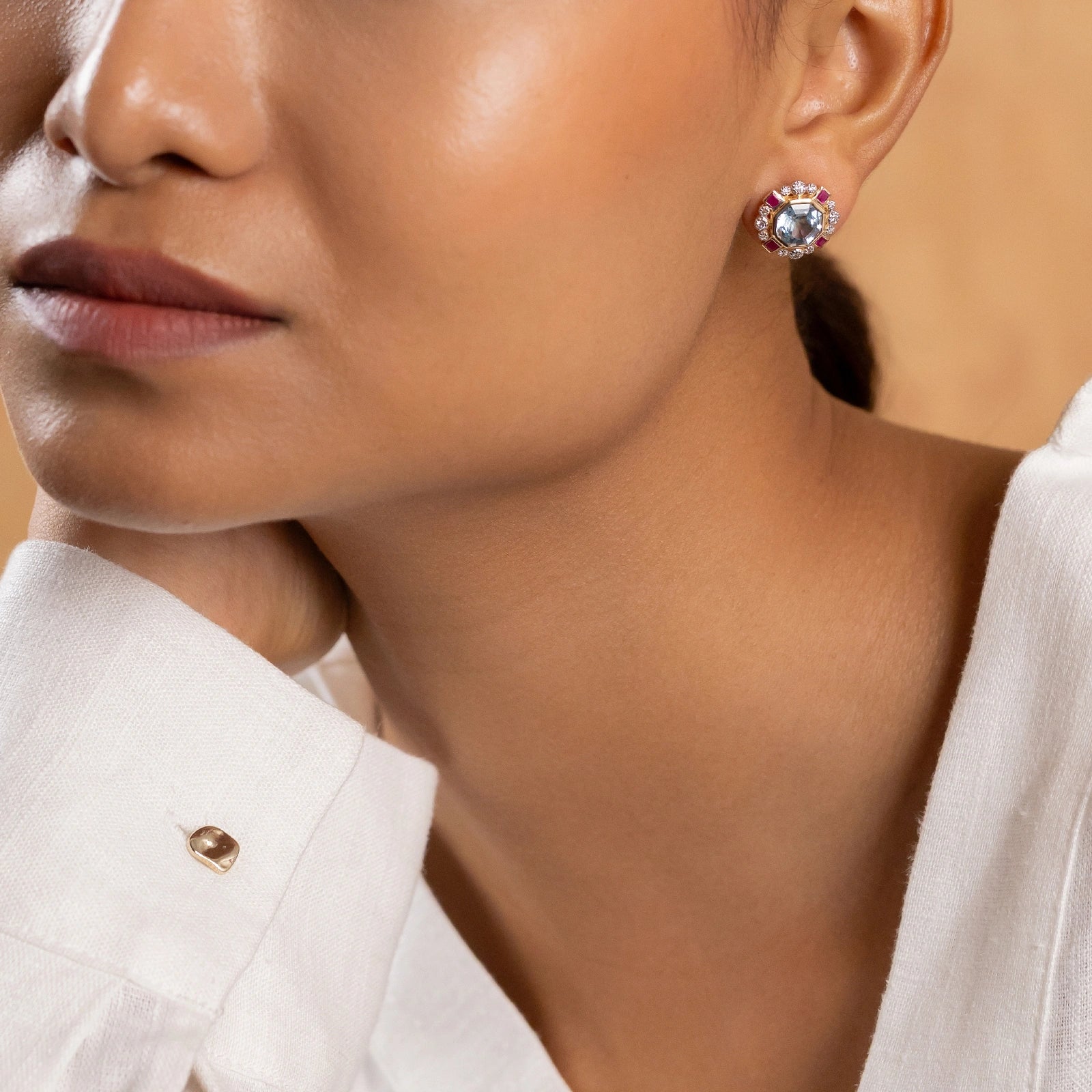 Elina ear studs in 14K gold with custom-cut blue topaz in an Art Deco frame with claw-set diamonds and bazel-set rubies