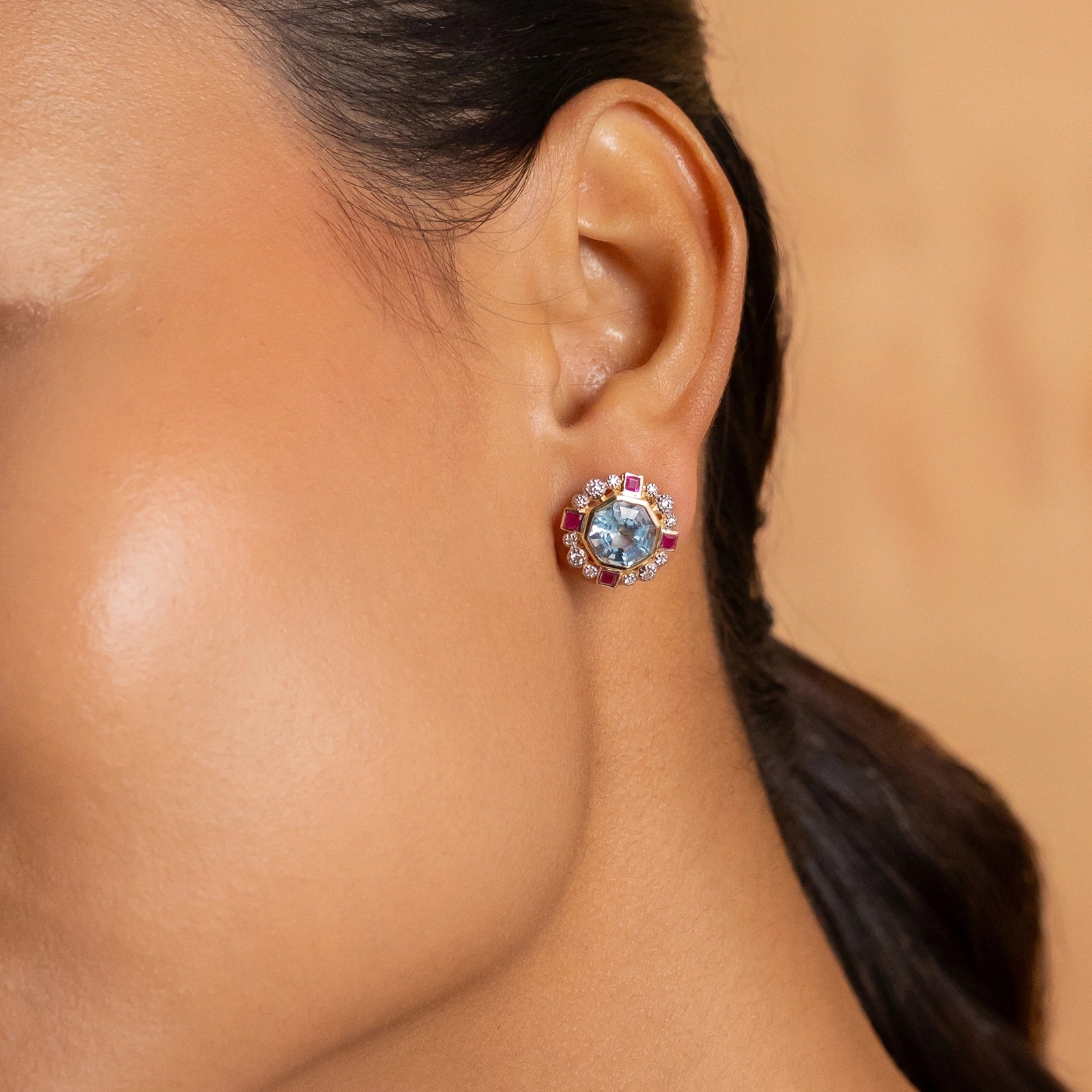 Elina ear studs in 14K gold with custom-cut blue topaz in an Art Deco frame with claw-set diamonds and bazel-set rubies