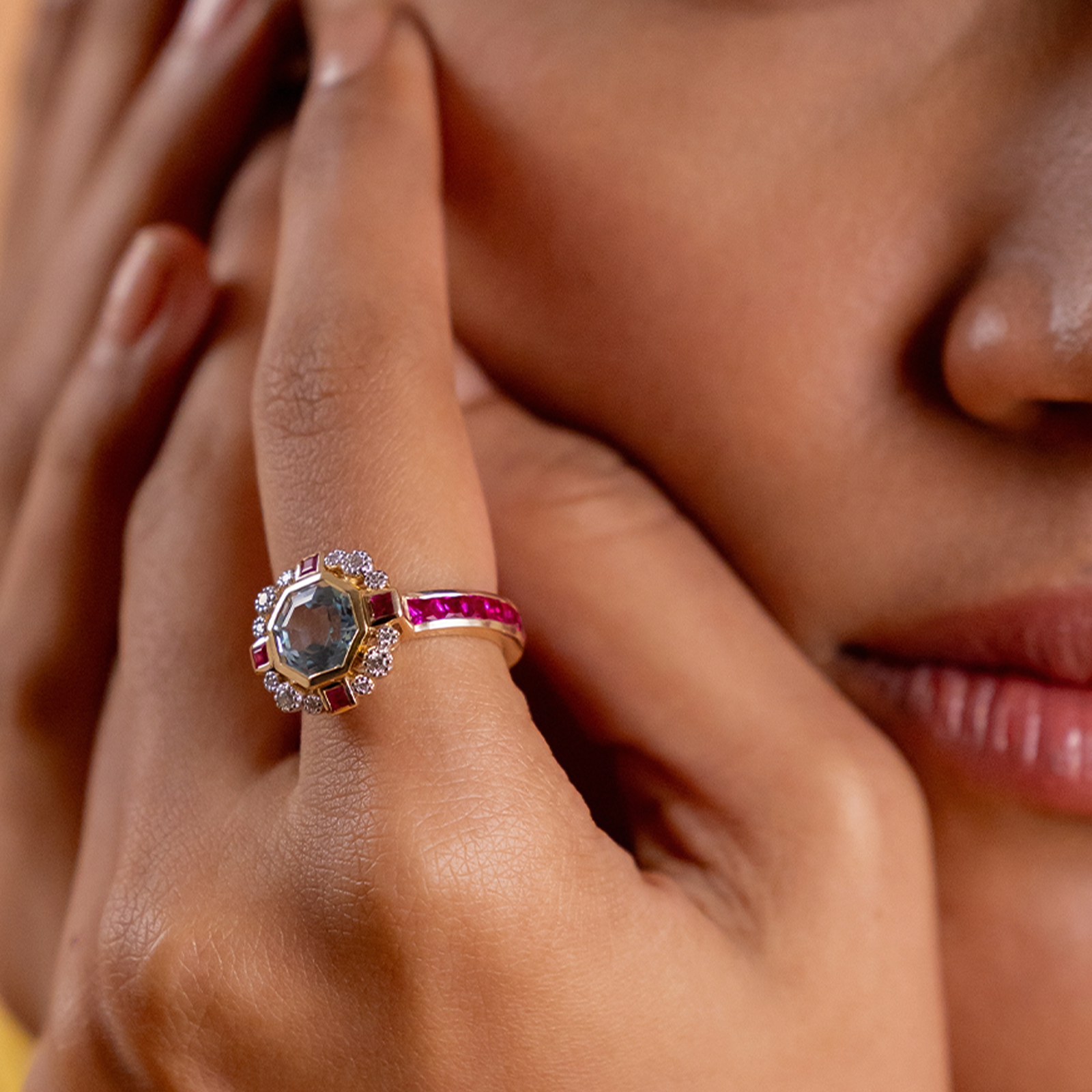 Elina Ring in 14K gold with custom-cut blue topaz in an Art Deco frame with claw-set diamonds, bazel-set rubies and channel-set topaz
