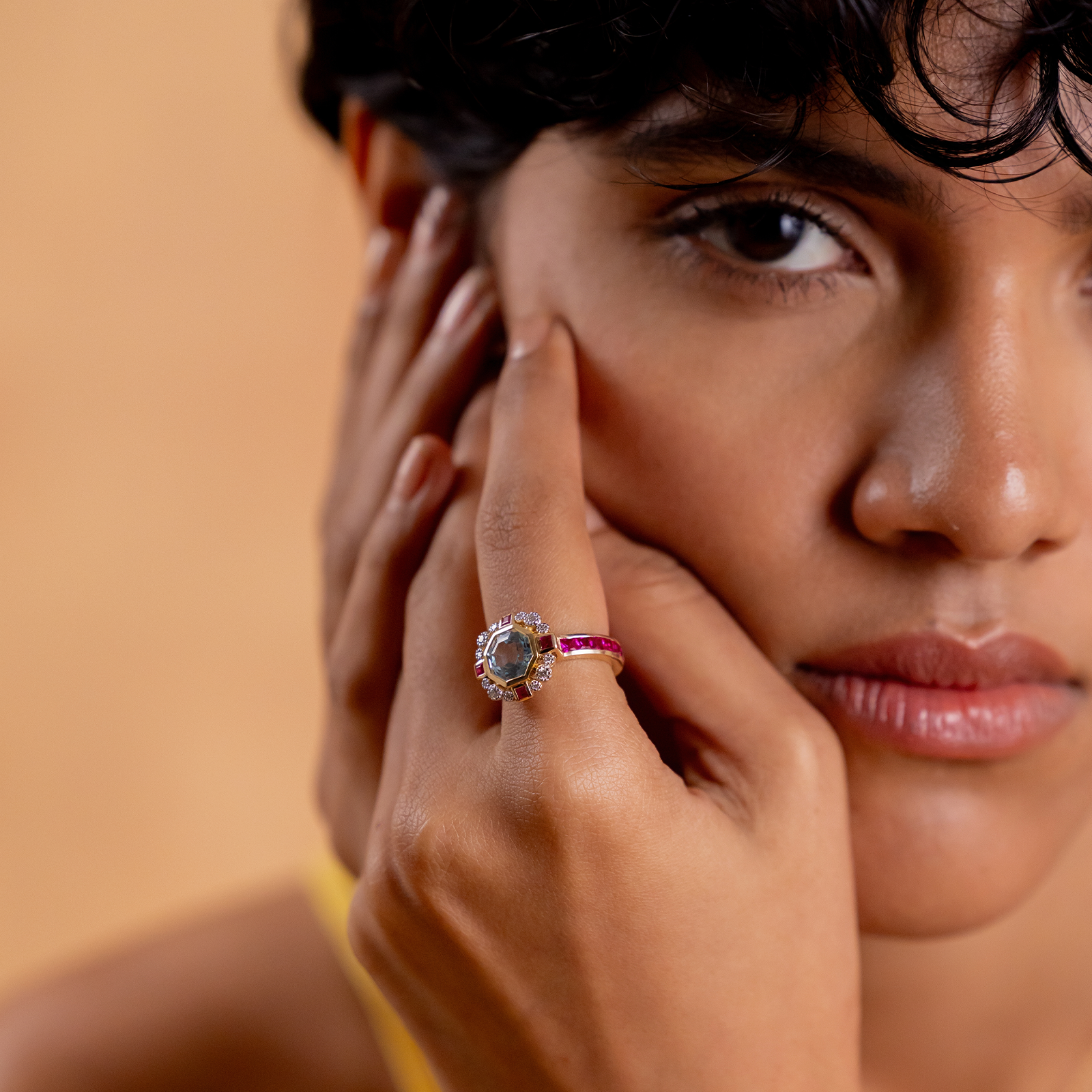 Elina Ring in 14K gold with custom-cut blue topaz in an Art Deco frame with claw-set diamonds, bazel-set rubies and channel-set topaz