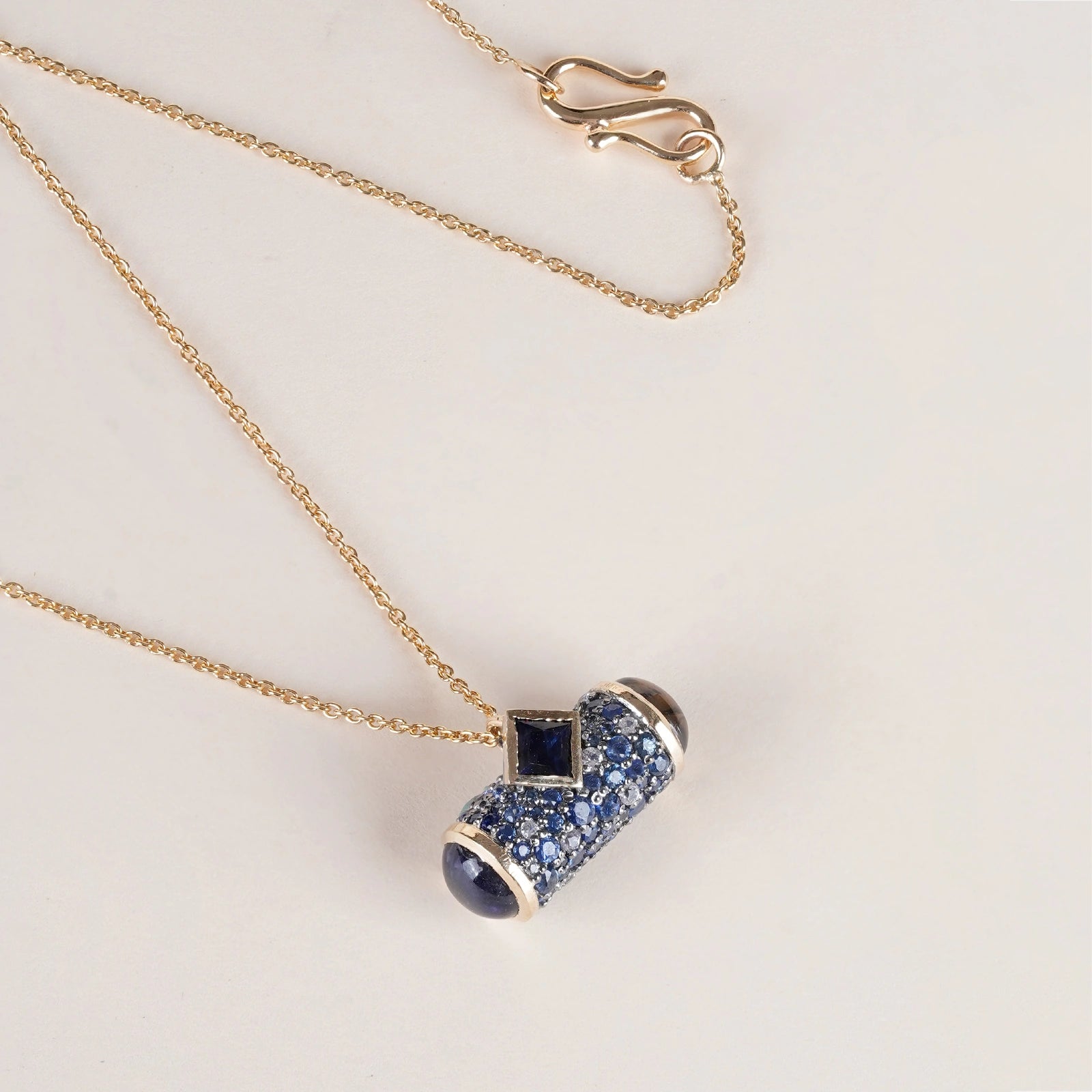 Evra Sky Pendant Necklace in 14K gold and 925 silver featuring a sapphire pavé amulet face with a bazel-set cabochon iolite in deep blue