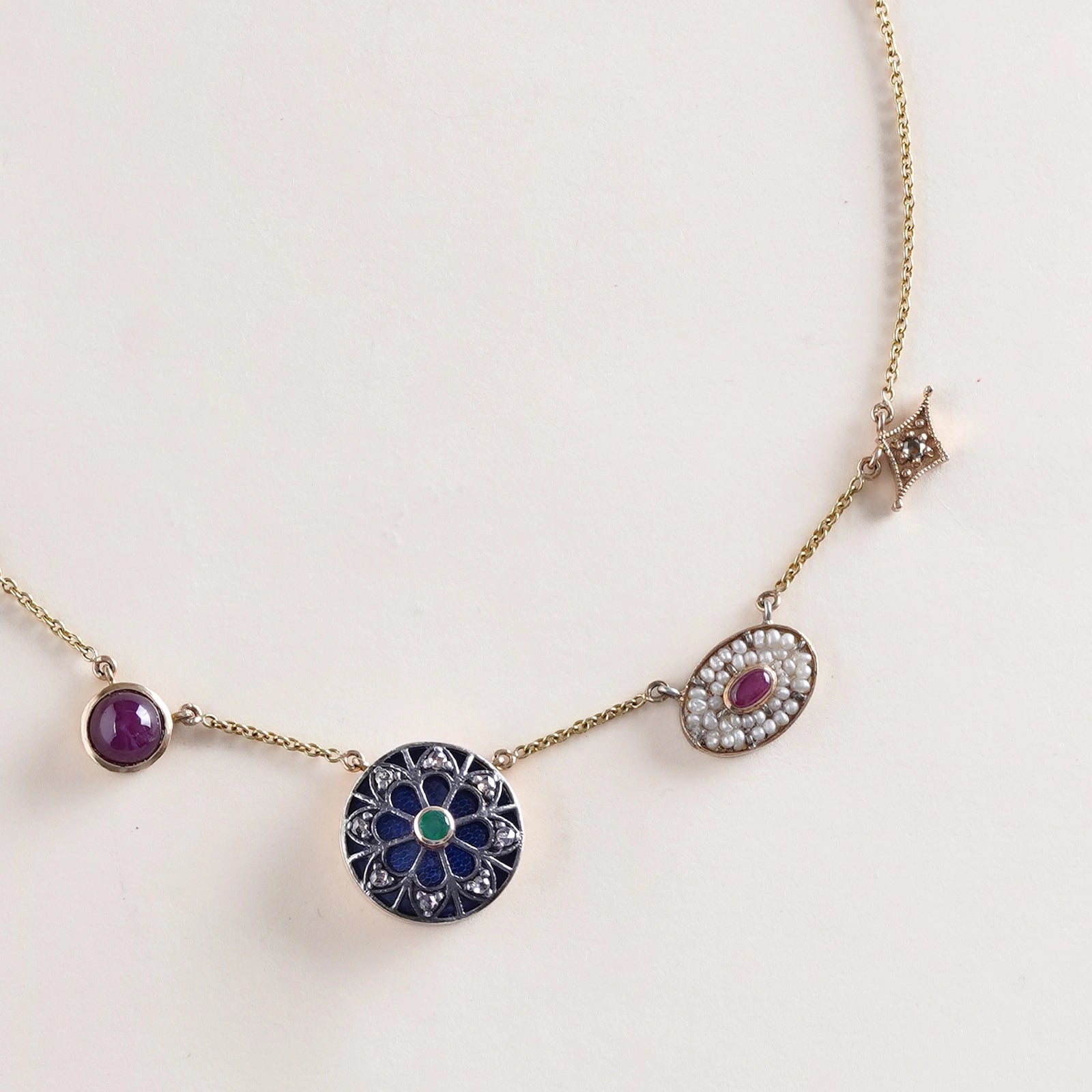 Firdos Charm Necklace in 14K gold with five handcrafted charms featuring rose-cut diamonds, emerald, ruby cabochon, yellow onyx and pearls