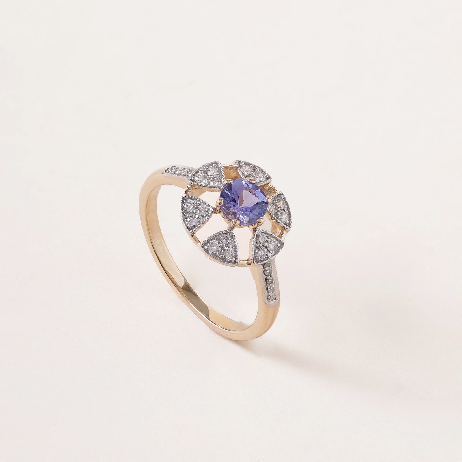 Laura Ring in 14K gold with tanzanite centre stone in a floral-inspired setting framed by natural brilliant-cut diamonds