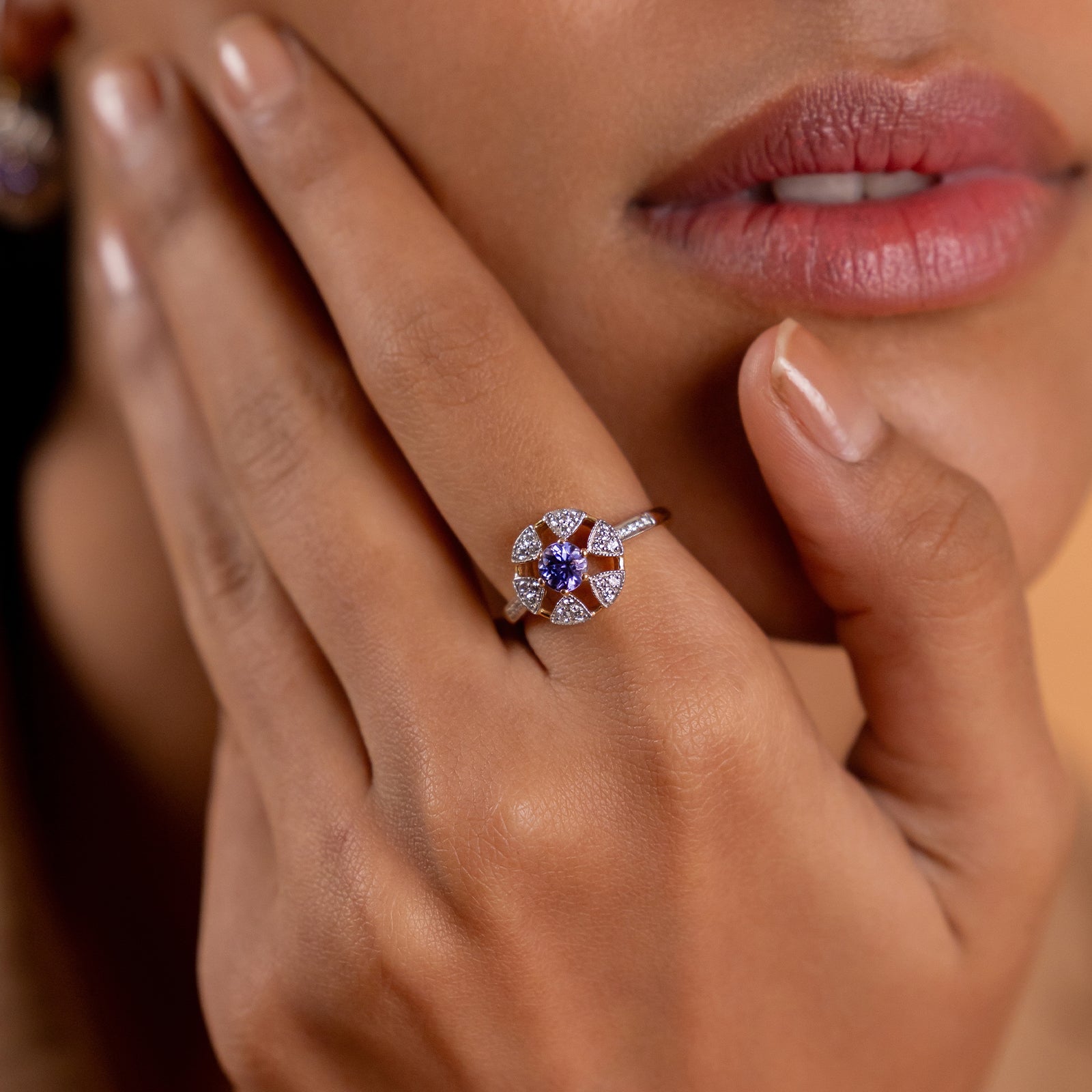 Laura Ring in 14K gold with tanzanite centre stone in a floral-inspired setting framed by natural brilliant-cut diamonds