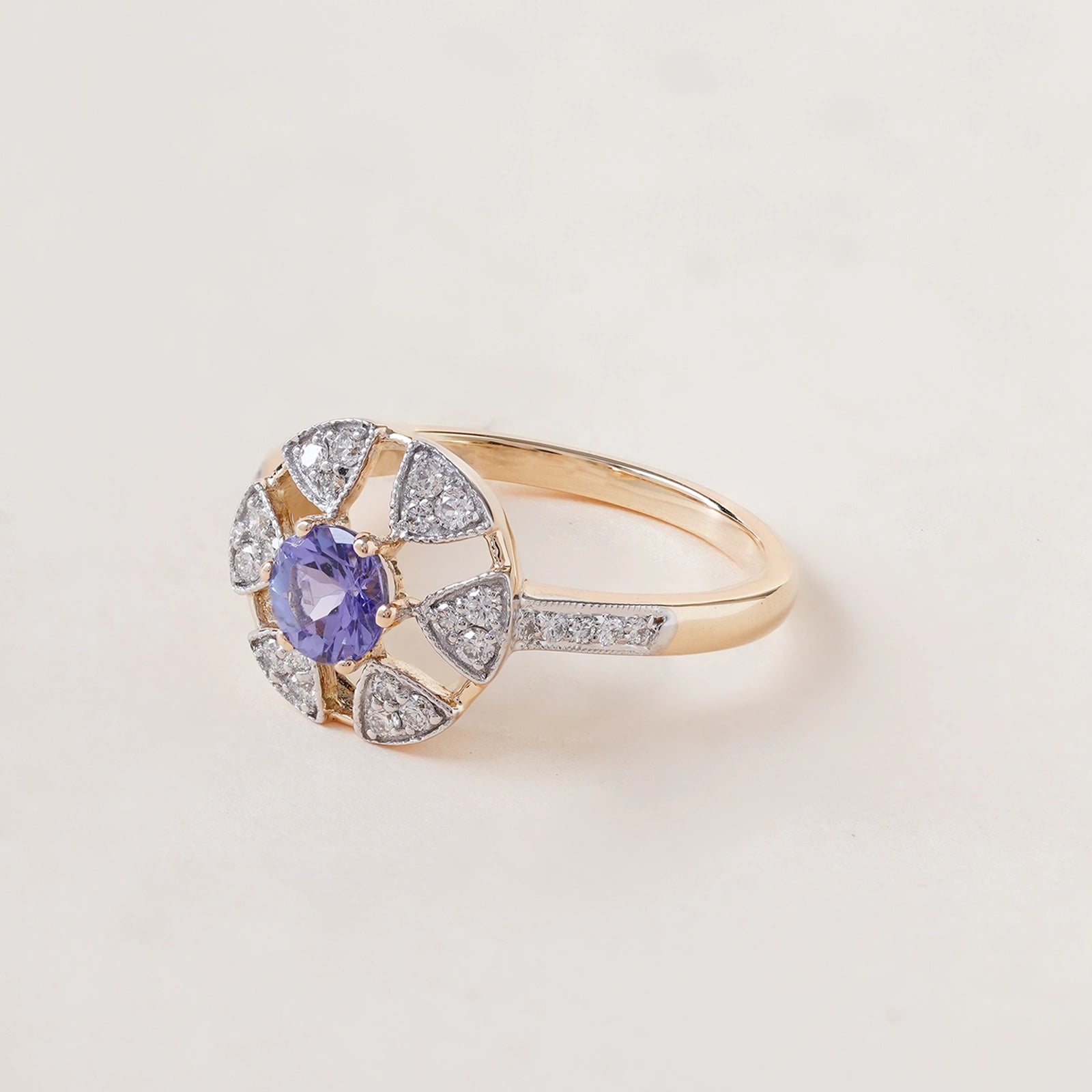 Laura Ring in 14K gold with tanzanite centre stone in a floral-inspired setting framed by natural brilliant-cut diamonds