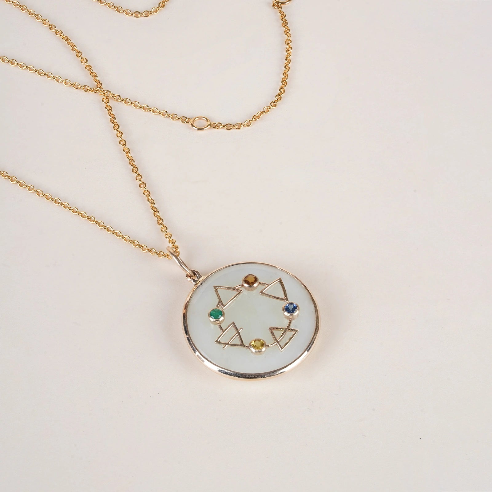 Maya Elements of Life Pendant in 14K gold with emerald, hessonite, yellow sapphire and blue sapphire on a serpentine base with coloured enamel
