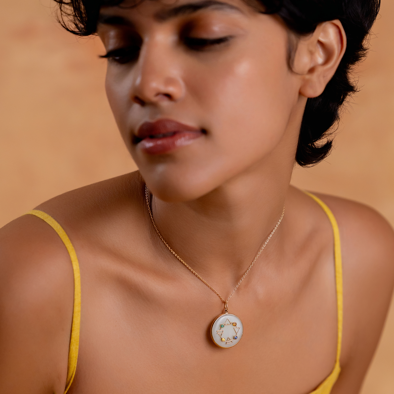 Maya Elements of Life Pendant in 14K gold with emerald, hessonite, yellow sapphire and blue sapphire on a serpentine base with coloured enamel