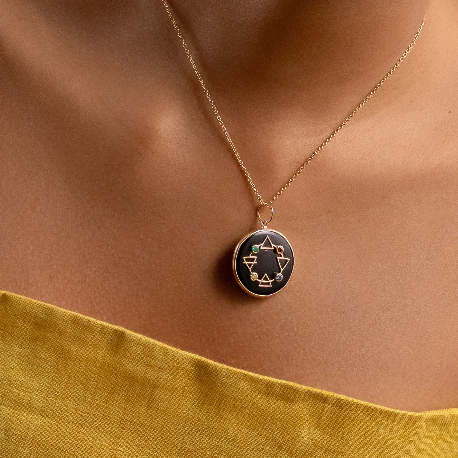 Maya Elements of Life Pendant in 14K gold with emerald, hessonite, yellow sapphire and blue sapphire on a black onyx base with coloured enamel