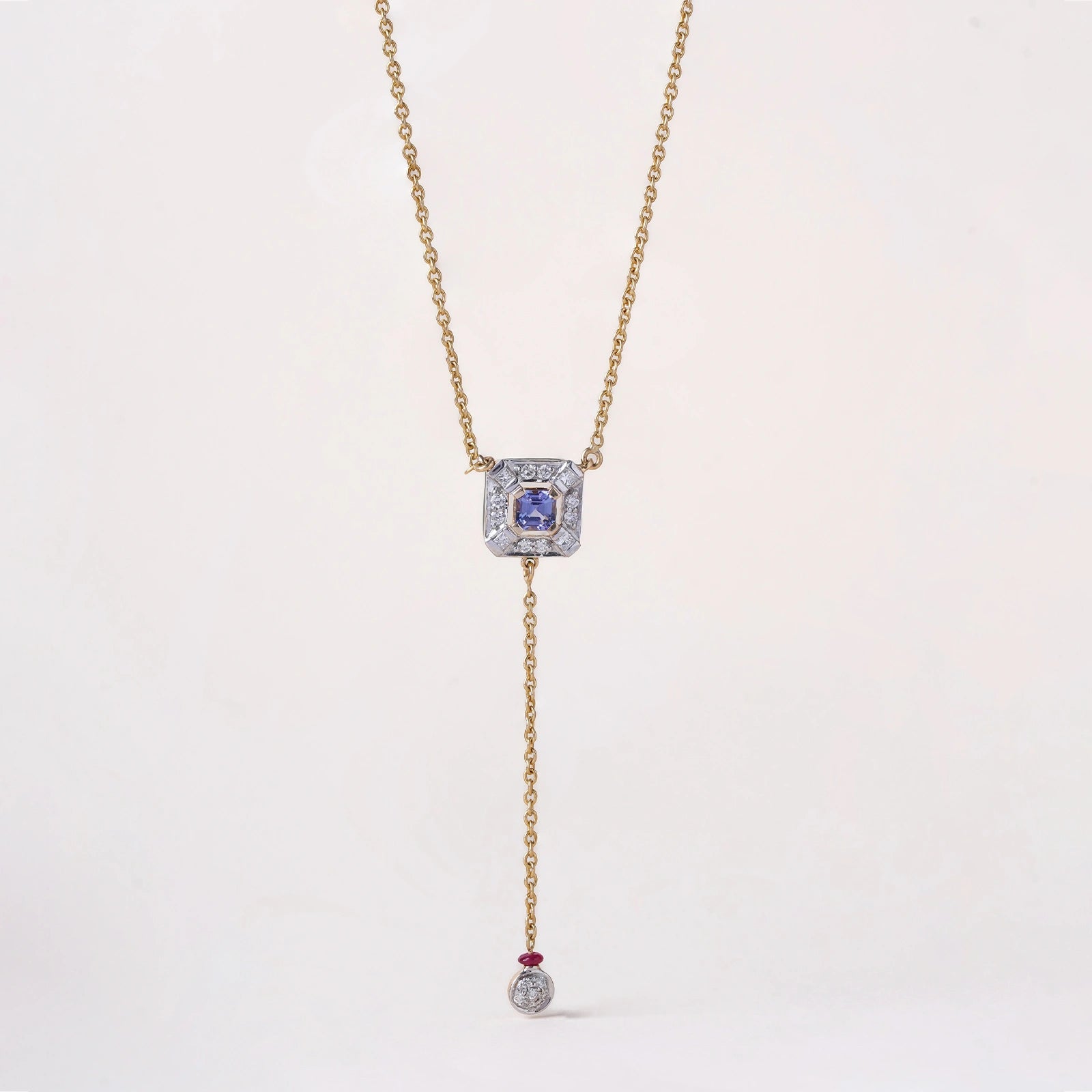 Nizam Tanzanite Pendant Necklace handcrafted in gold featuring a central tanzanite, brilliant and princess cut diamonds, green enamel detailing, and delicate dangling accents inspired by Indian artistry.