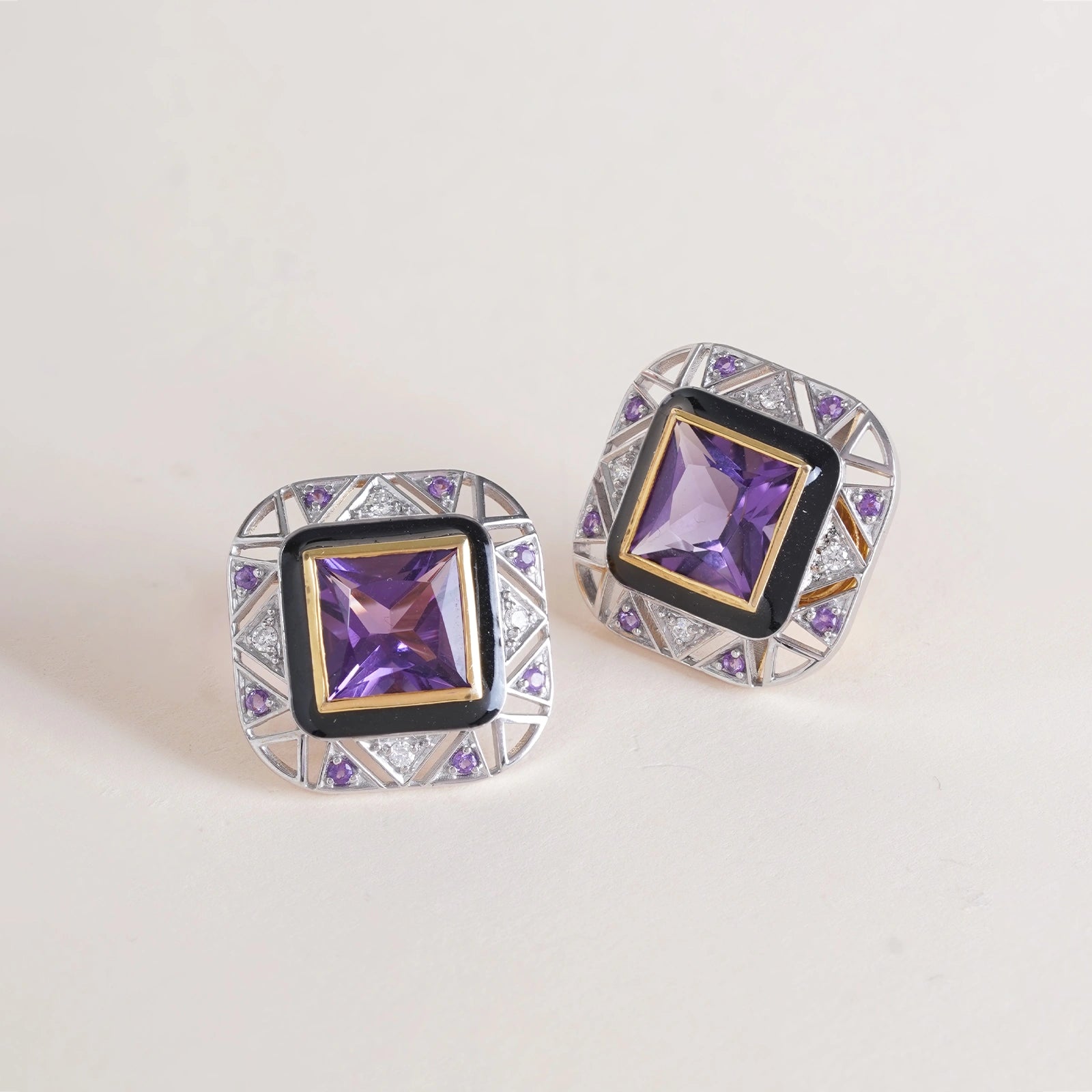 Discover the Odette Ear Studs in 14K gold on a 925 silver base. A custom-cut princess amethyst framed by natural brilliant-cut diamonds and finished with black enamel for a clean, graphic edge. Art Deco in spirit, effortless from the office into the evening.