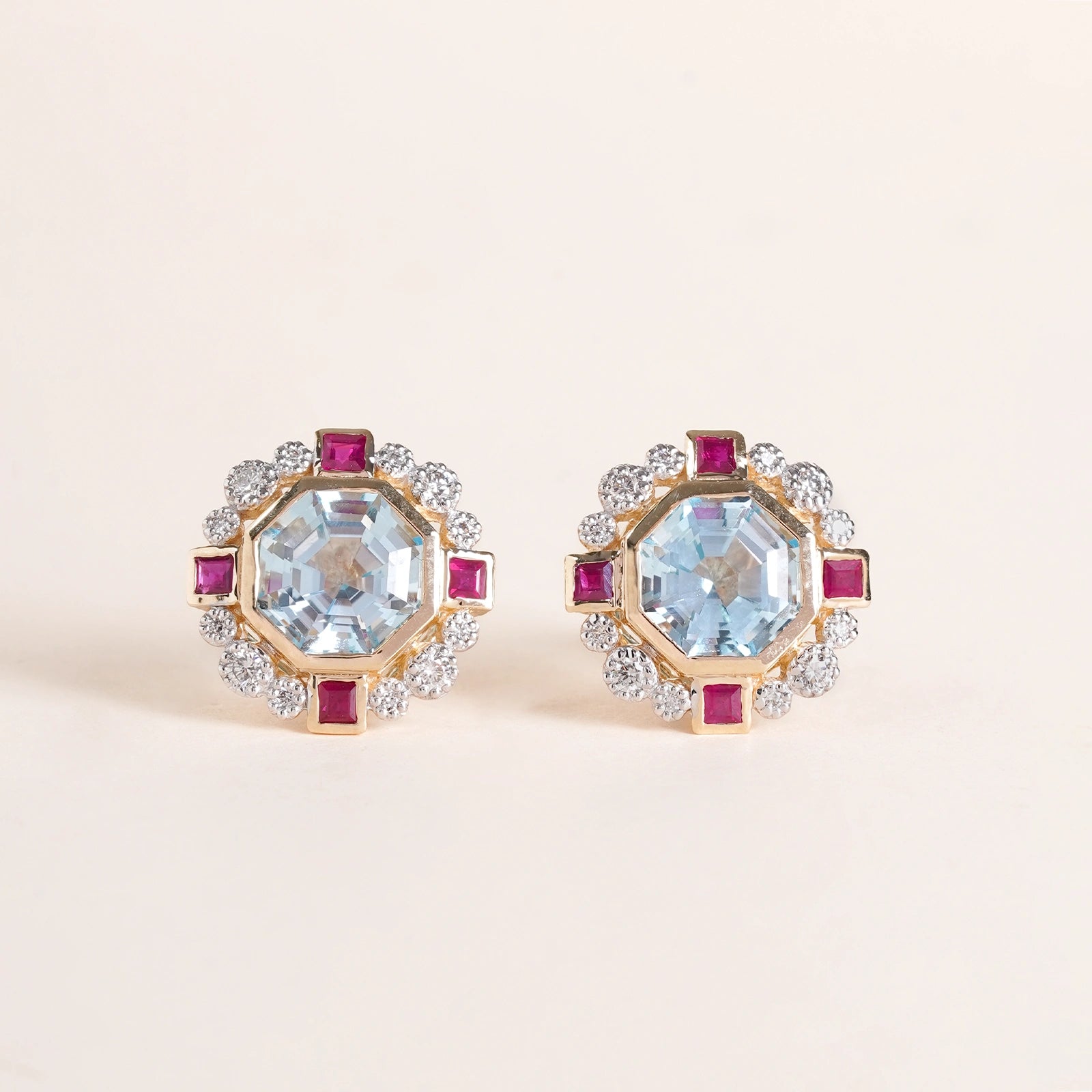 Elina ear studs in 14K gold with custom-cut blue topaz in an Art Deco frame with claw-set diamonds and bazel-set rubies
