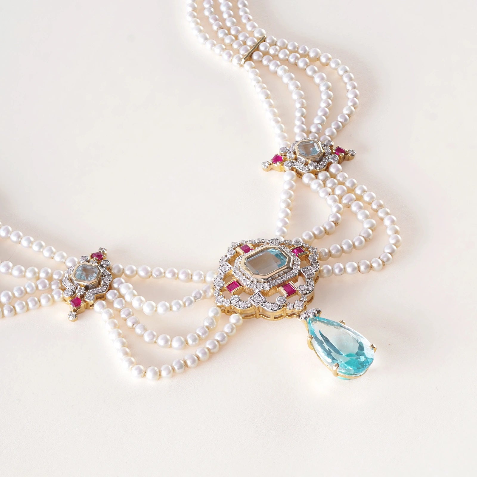 Close-up of the blue topaz centrepiece framed in natural brilliant-cut diamonds and small square rubies