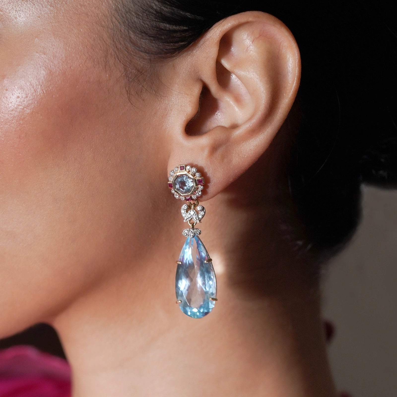 Close-up of the eight-sided blue topaz framed in natural brilliant-cut diamonds and square rubies