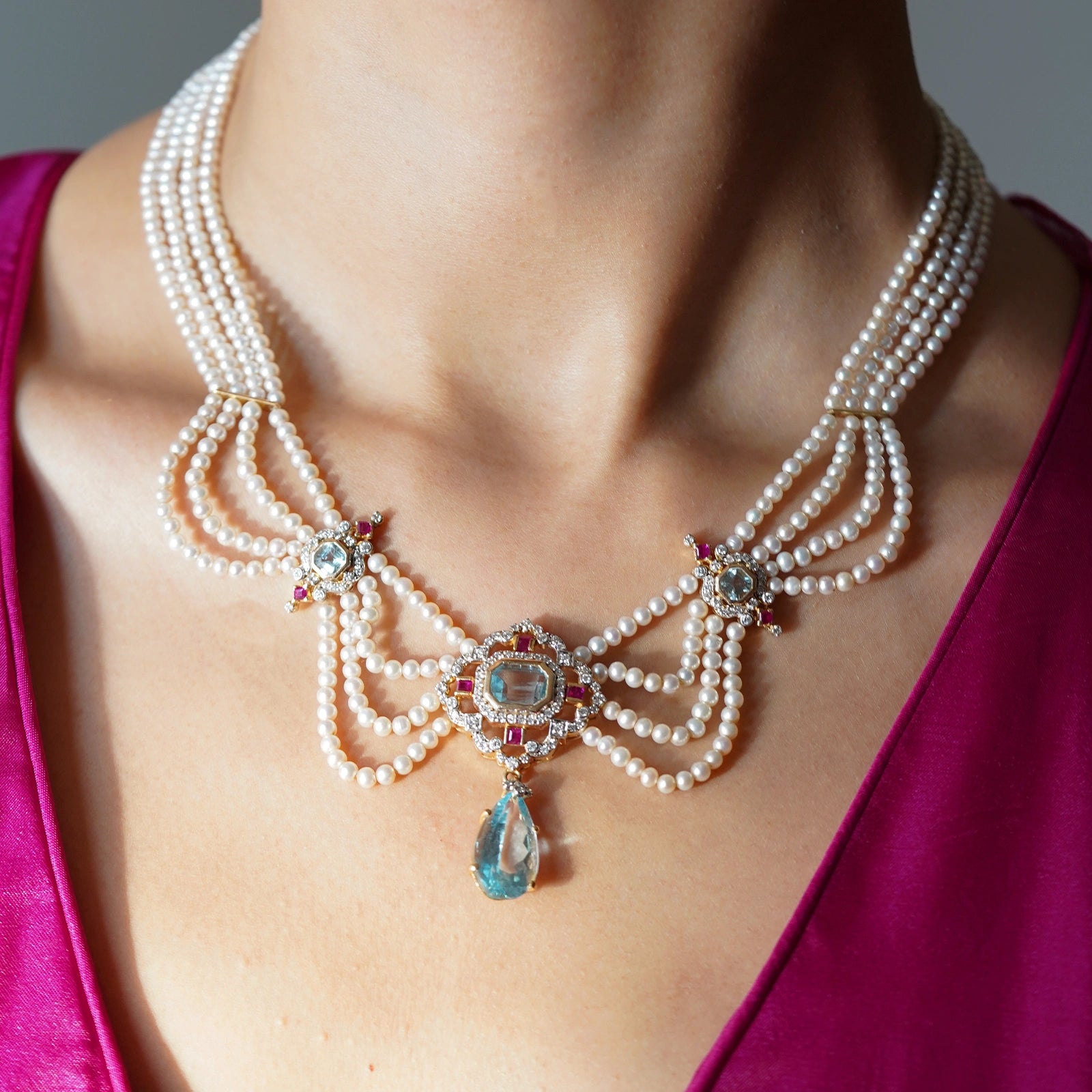 Model wearing a blue topaz and pearl necklace for a festive evening