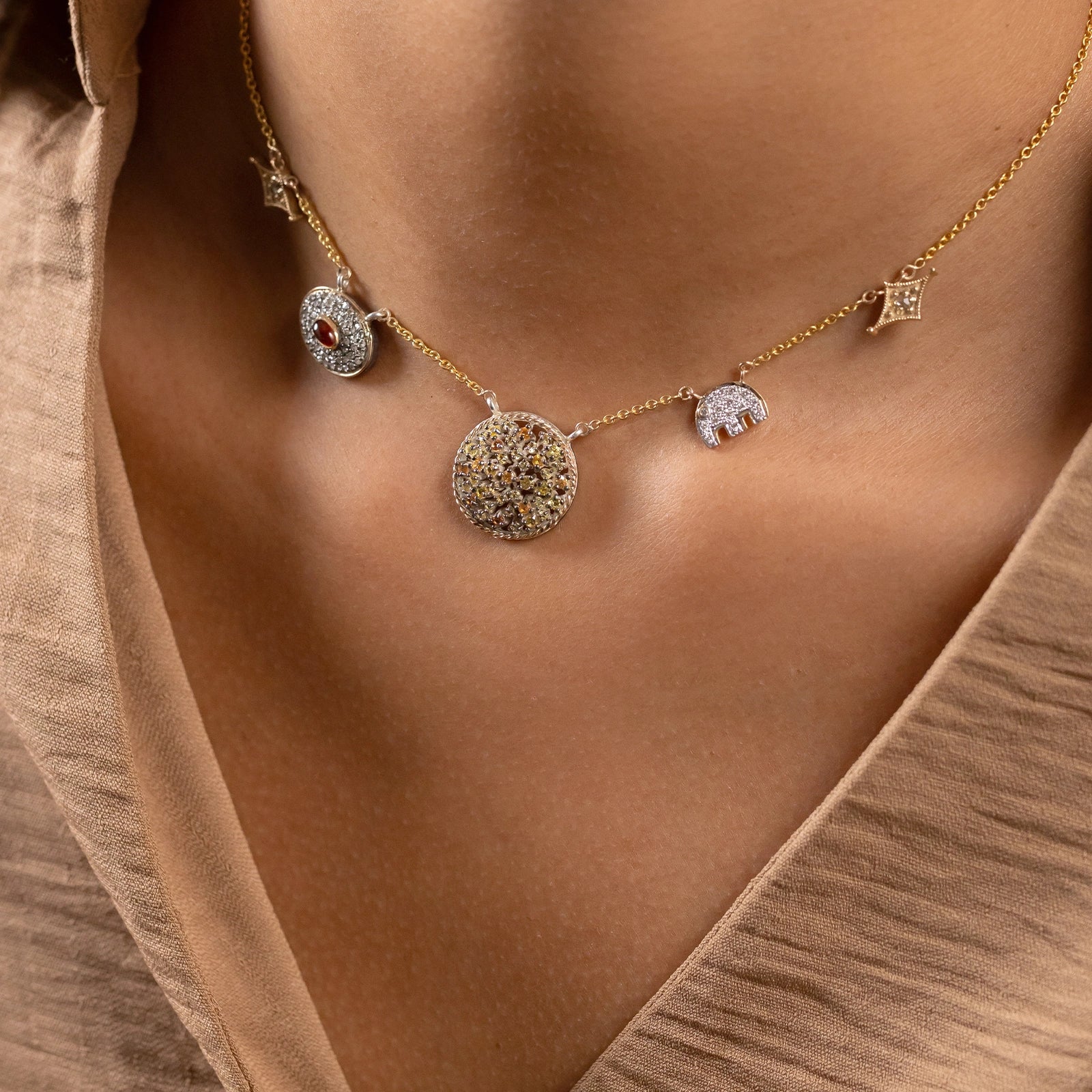 Zora Charm Necklace in 14K gold with four handcrafted charms featuring rose-cut diamonds, sapphire, hessonite and a diamond elephant